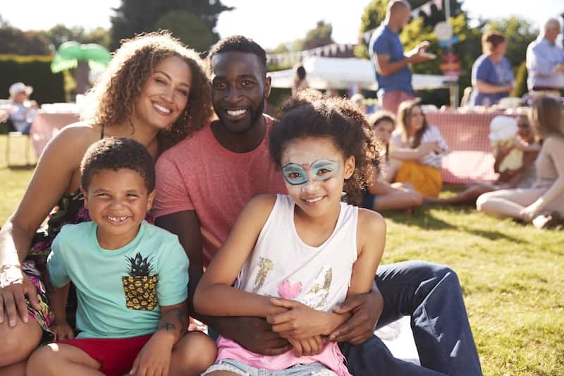 Mother, father and two black children smiling