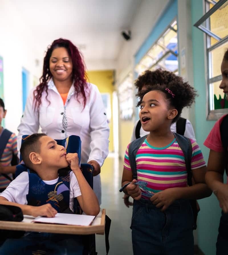 three black children with various disabilities at school